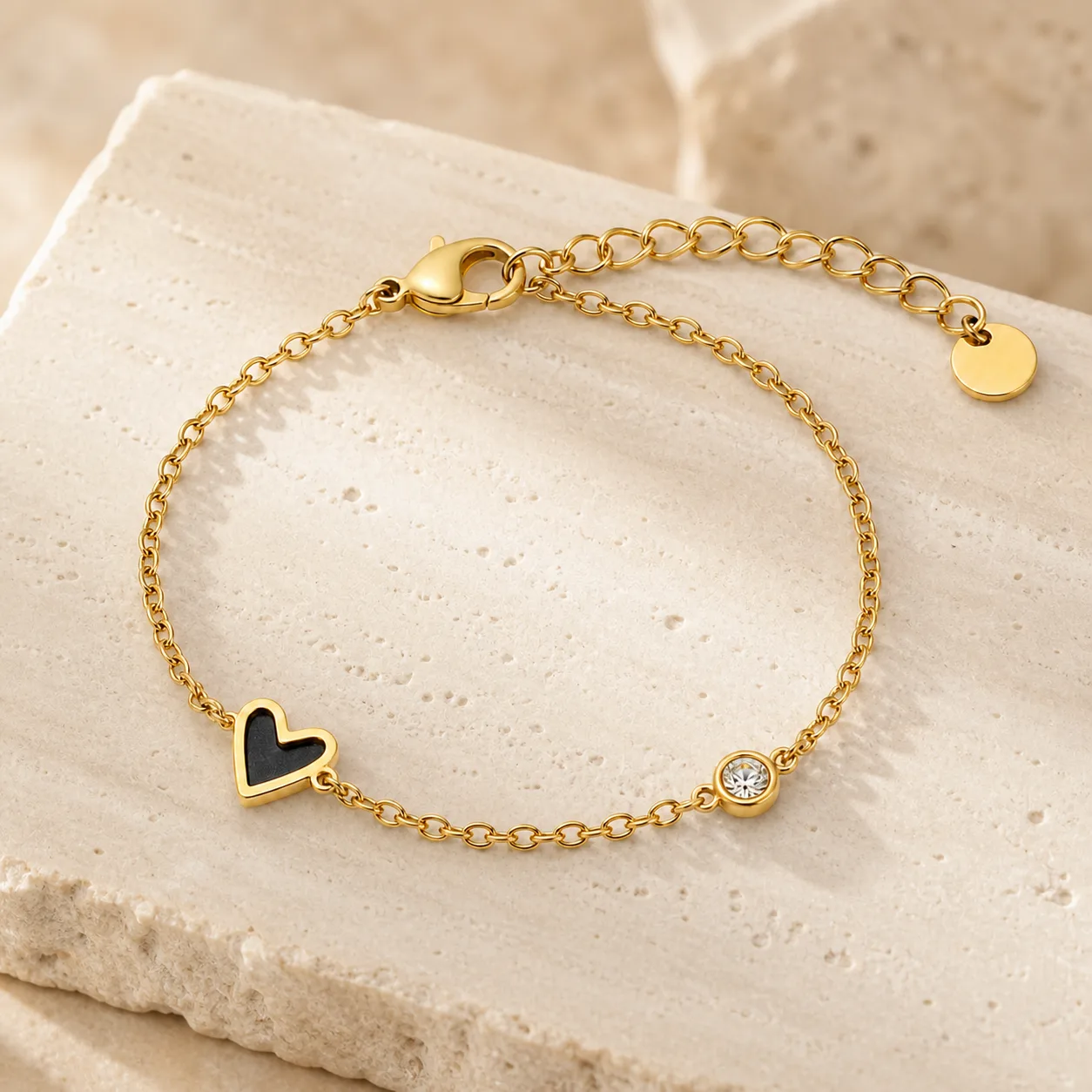 pulseira dourada com coração preto sobre pedra clara, referência 85382-3