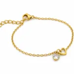 pulseira dourada com coração de cristal em fundo branco, referência 85383-3