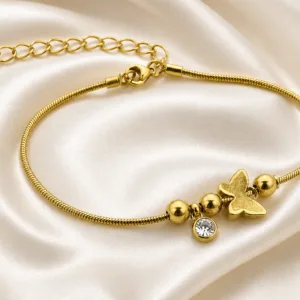 pulseira dourada com borboleta, contas e cristal em cetim marfim, referência 85383-4