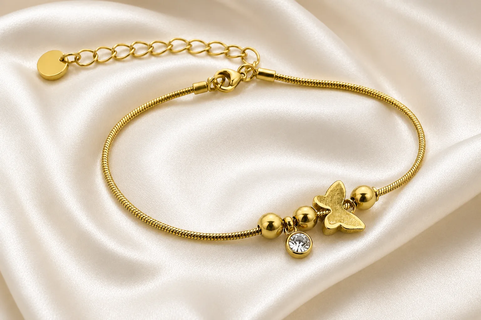 pulseira dourada com borboleta, contas e cristal em cetim marfim, referência 85383-4