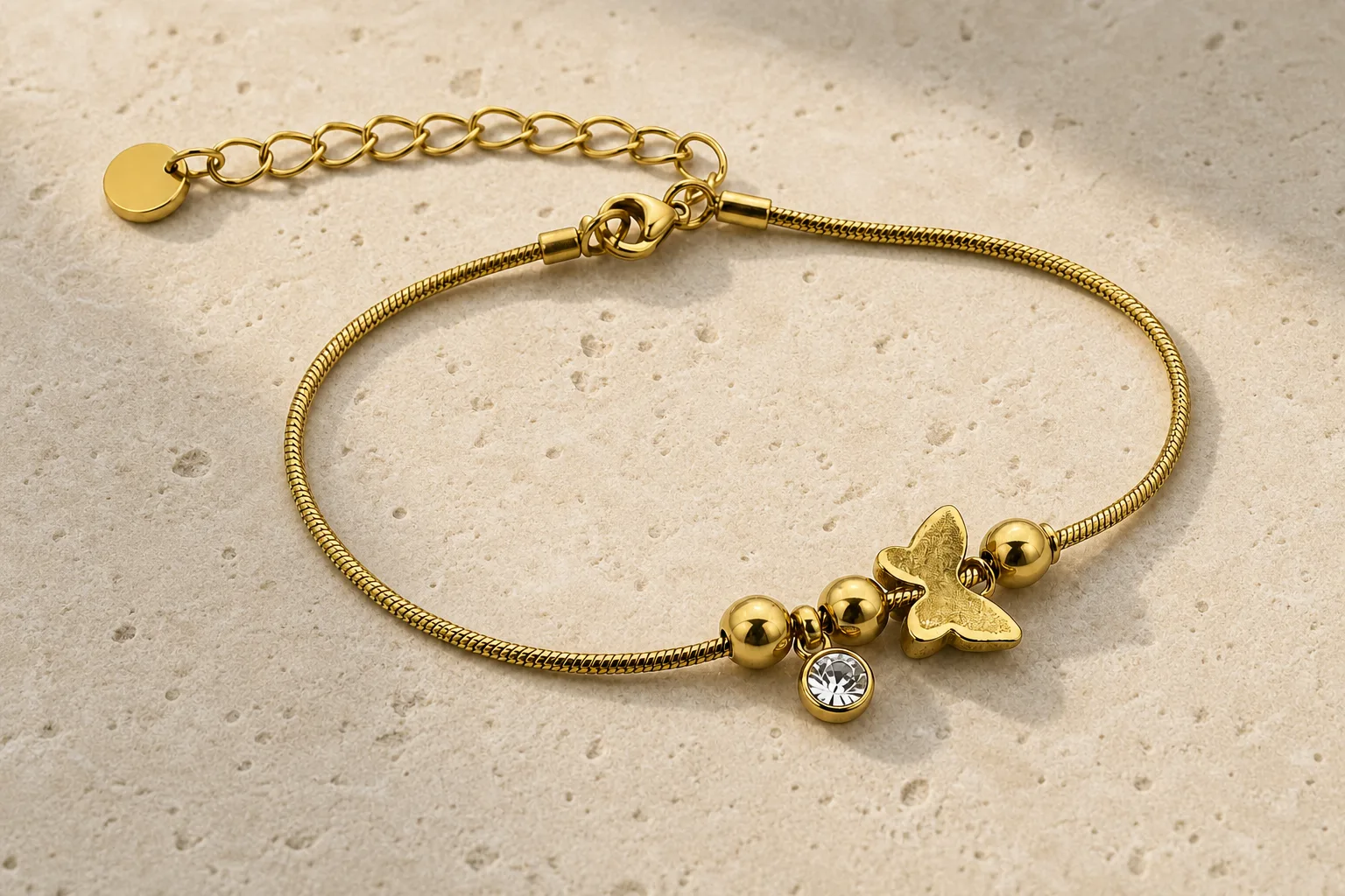 pulseira dourada com borboleta sobre pedra clara, referência 85383-4