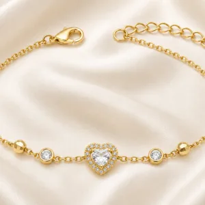 pulseira dourada com coração de cristal e halo em cetim marfim, referência 85384-5