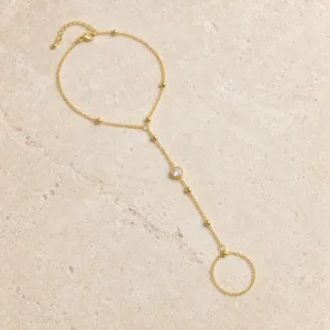 pulseira de mão dourada com cristal e anel em pedra clara de tom quente, referência 85384-6