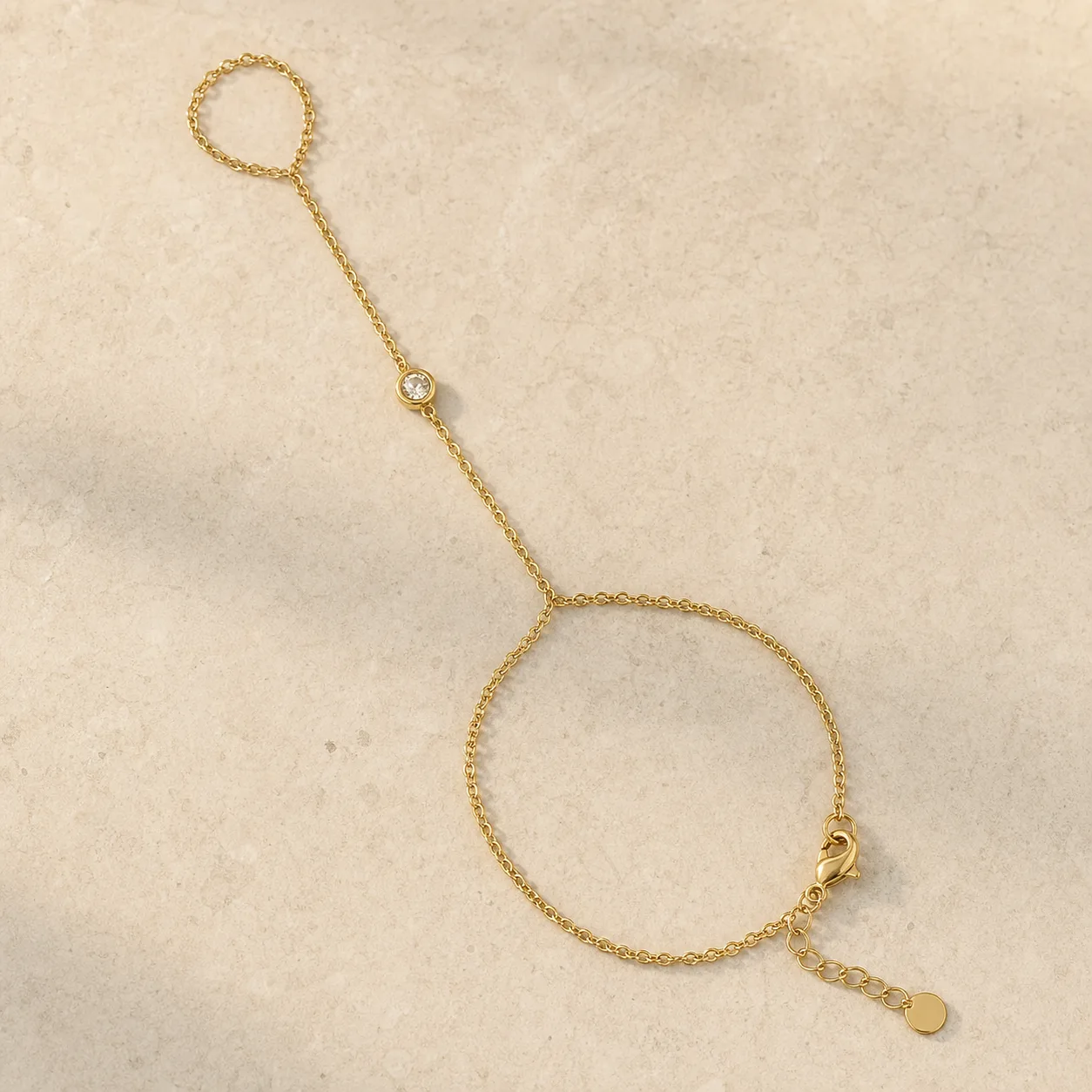 pulseira de mão dourada minimalista sobre pedra clara, referência 85473-1