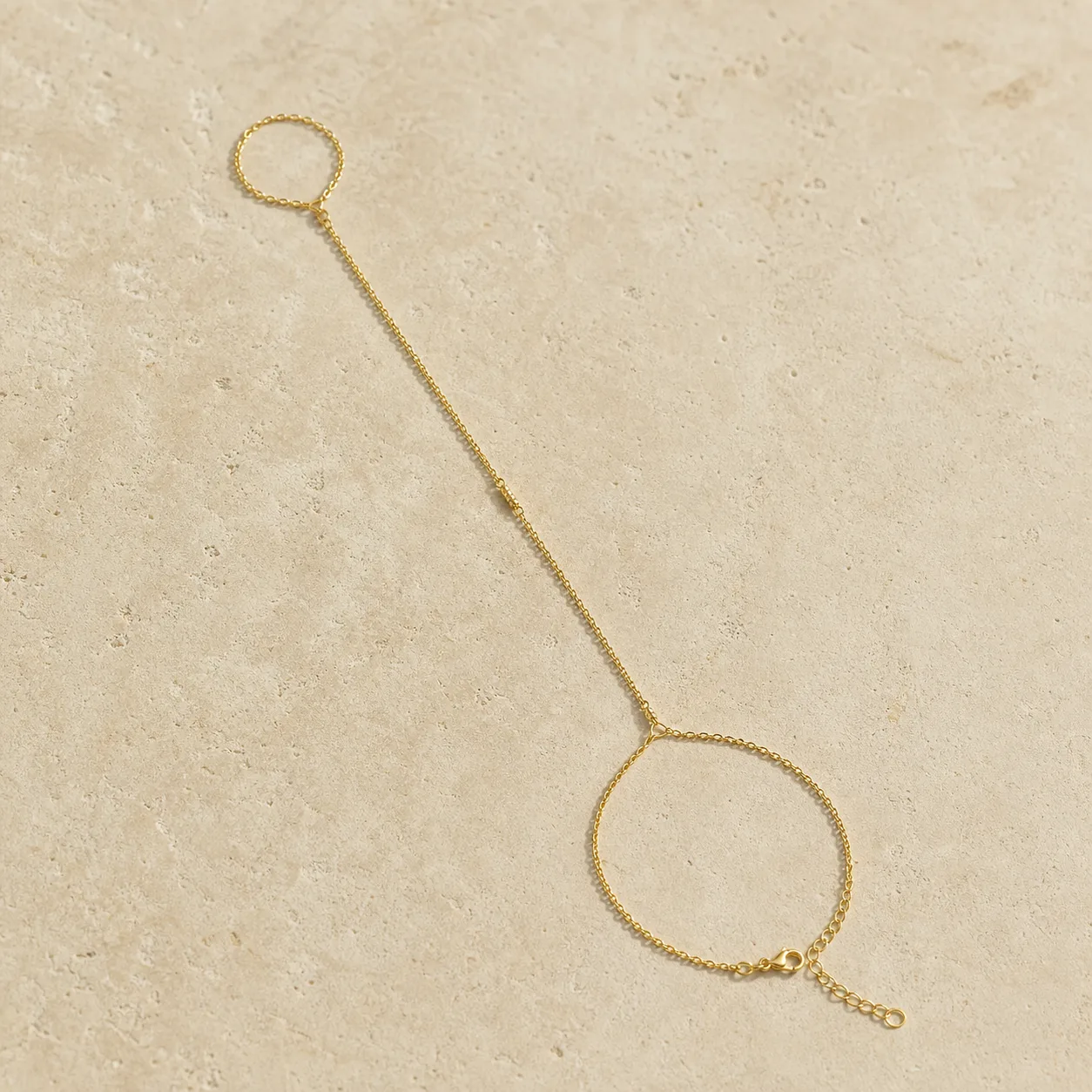 pulseira de mão dourada lisa sobre pedra clara, referência 85474-1