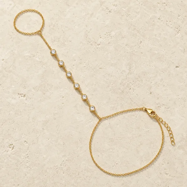 pulseira de mão dourada com seis cristais em pedra clara de tom quente, referência 85474-3