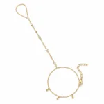 pulseira de mão dourada com quatro cristais e contas em fundo branco, referência 85475-1