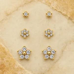Conjunto de 3 pares de brincos florais dourados sobre pedra de tom quente