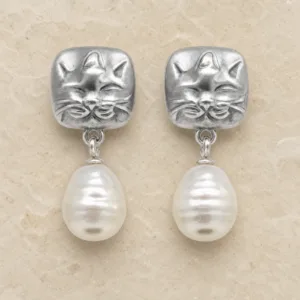 Brincos prateados de gato com pérolas sobre pedra de tom quente