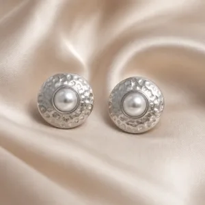 Brincos prateados martelados com pérolas sobre cetim bege claro