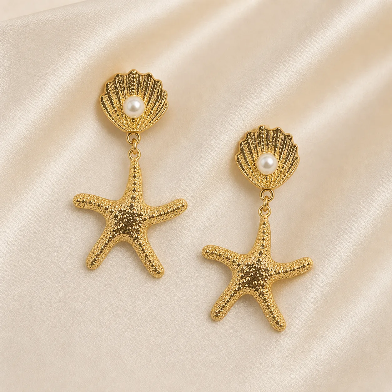 Brincos dourados de concha e estrela-do-mar 5290-S018-1A sobre cetim bege claro, conchas com p?rolas e estrelas-do-mar