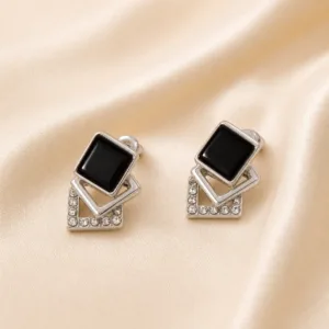 Brincos prateados geométricos com preto 5429-S008-1B sobre cetim bege claro